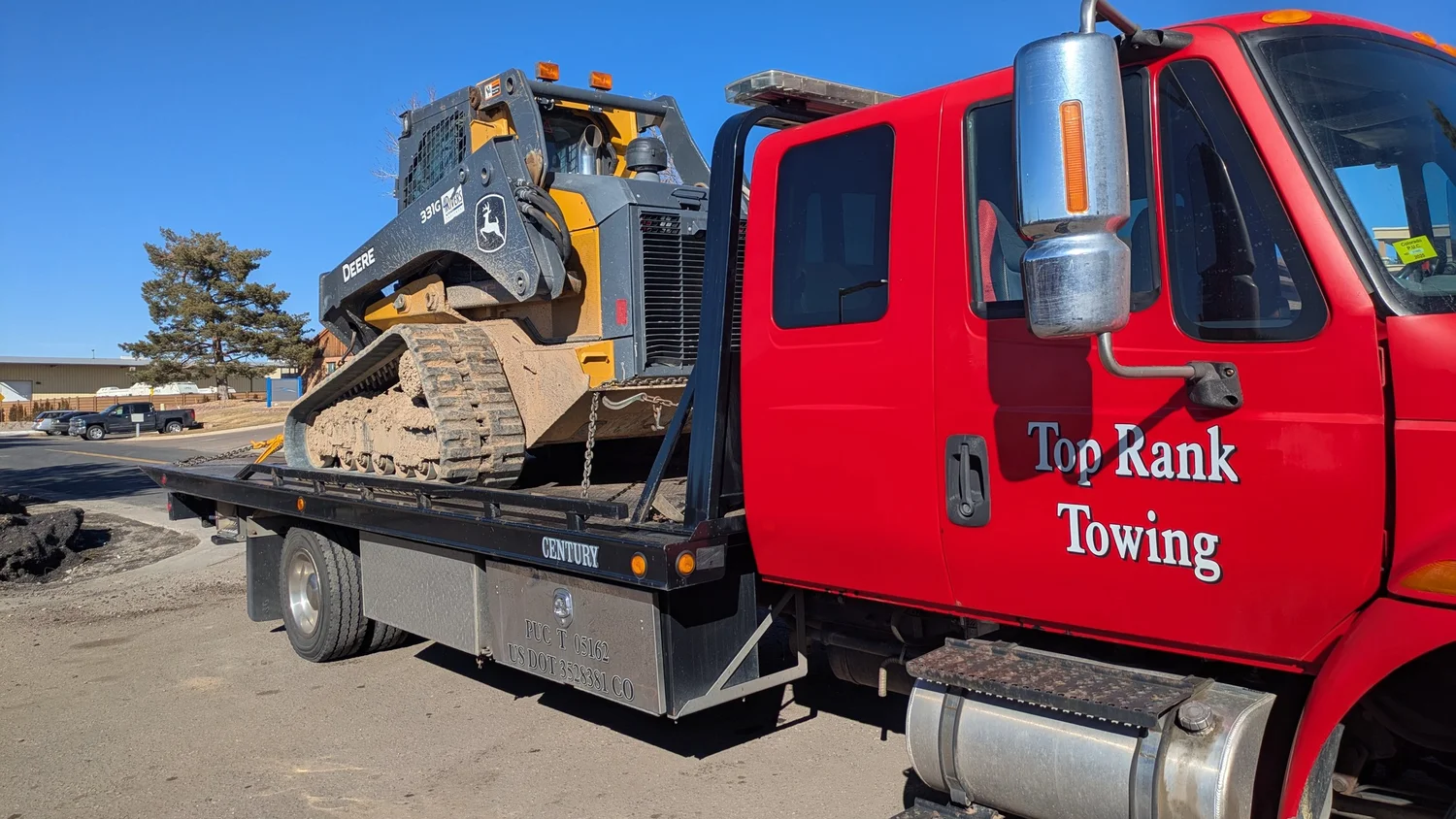 Flatbed hauling a Deere skid steer