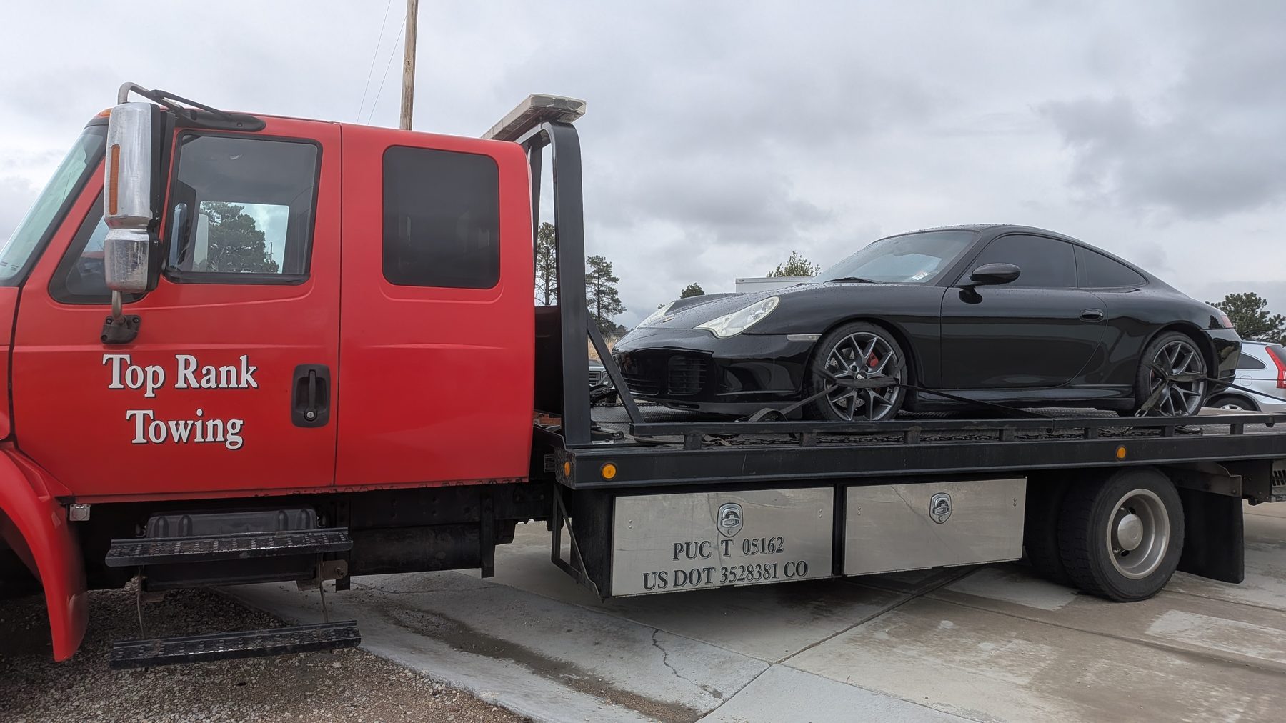 Top Rank Towing flatbed truck loaded with a Porsche 911